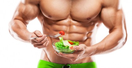 Shaped and healthy body man holding a fresh salad bowl isolated on white background colored retouched